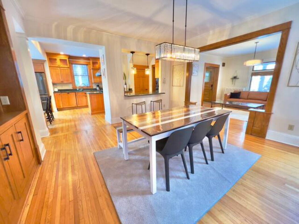A spacious kitchen with wooden cabinets, a large island, and a dining area with a long table and chairs.