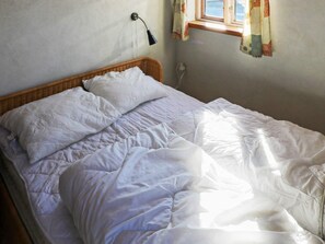 A bed with white bedding, a wall-mounted lamp, and a window with curtains. - 4 Star Holiday Home in Hadsund (Hadsund)