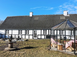 Un bâtiment traditionnel doté d’un toit à pignon et d’une véranda en verre.