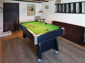 A pool table with balls, a chalkboard with writing, a framed picture, and a shelf with items. - 4 Star Holiday Home in Hadsund (Hadsund)