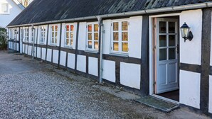 A building with a black roof and white walls, featuring multiple windows and a door. - 4 Star Holiday Home in Hadsund (Hadsund)