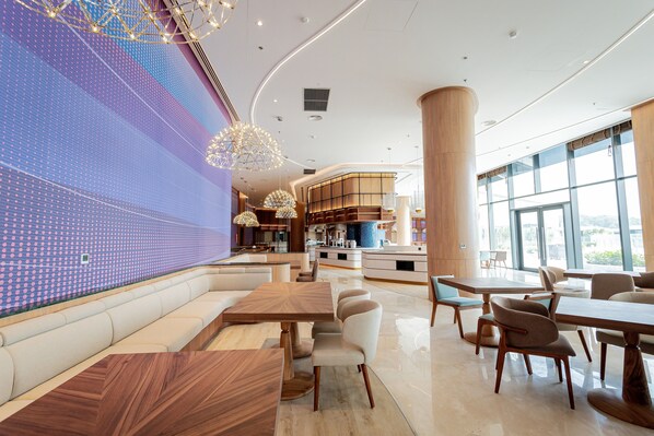 Un restaurante moderno con una barra larga, zona de estar y ventanas amplias.