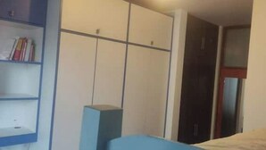 Une chambre à coucher comprenant un lit, une armoire, un bureau et une bibliothèque.