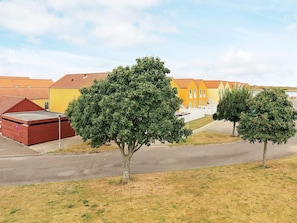 A residential area with houses, a paved road, and two trees. - 4 Star Holiday Home in Rudkobing (Rudkobing)