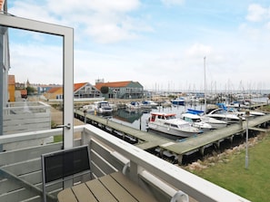Uma marina com barcos atracados, um edifício com telhado vermelho e vista para a água.