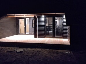 A modern house with a covered patio, large sliding glass doors, and a visible kitchen area. - 22 Person Holiday Home in Vaeggerlose (Vaeggerlose)