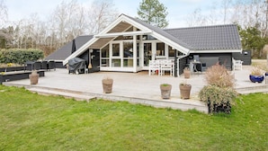 A modern house with a large patio, outdoor seating, and a covered area. - 10 Person Holiday Home in Stege (Stege)
