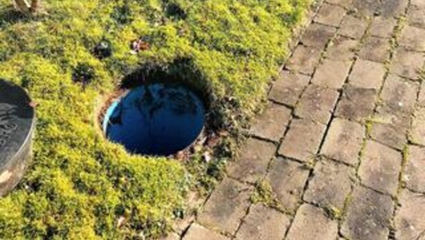 A circular hole in the ground surrounded by grass, next to a paved walkway. - 4 Star Holiday Home in Silkeborg (Silkeborg)