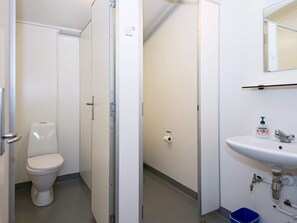 A small, clean bathroom with a toilet, a sink, and a mirror. - 20 Person Holiday Home in Herning (Herning)