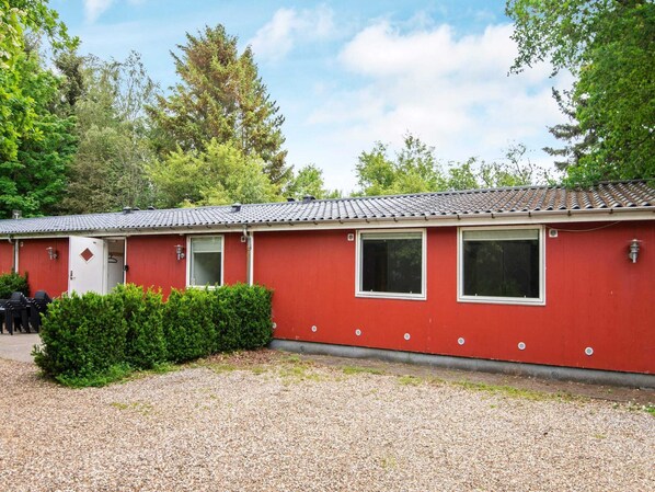 A red building with a tiled roof, a door, and windows. - 20 Person Holiday Home in Herning (Herning)