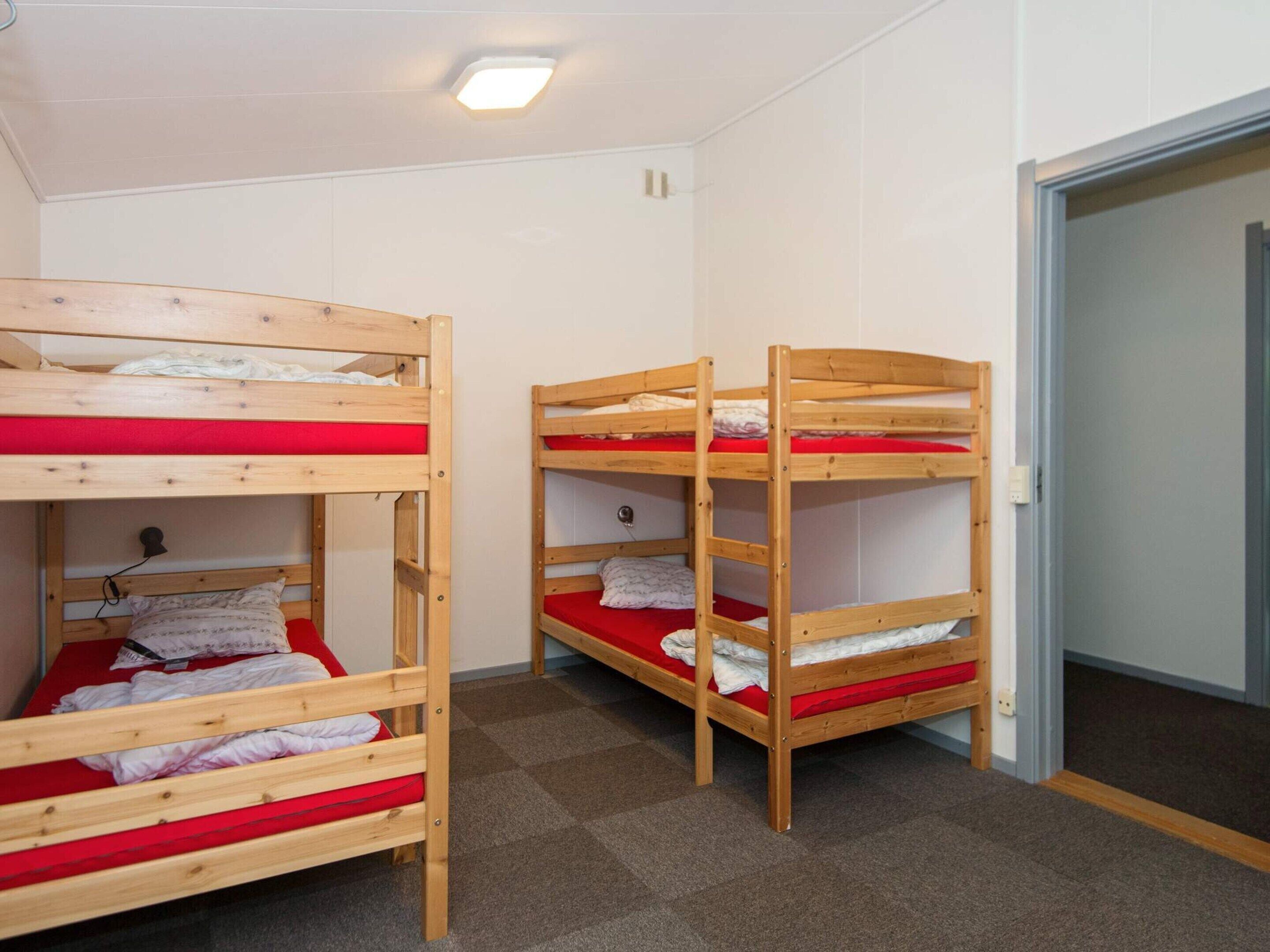 A room with bunk beds, carpeted floor, and a door.