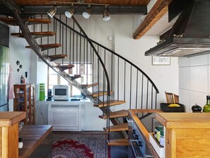 A kitchen with a wooden staircase, a white refrigerator, and a microwave on the counter. - 4 Star Holiday Home in Slite (Slite)