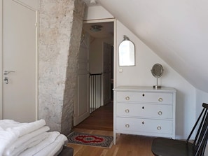 A bedroom with a white dresser, a mirror, a door, and a staircase leading to another room. - 4 Star Holiday Home in Slite (Slite)