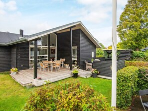 A modern house with a covered patio, outdoor seating, and a garden. - 4 Star Holiday Home in Malling (Malling)