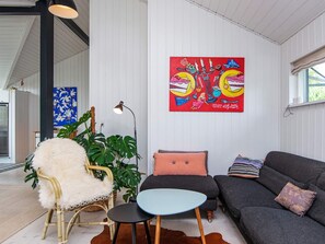A room with a sofa, a chair, a small table, a lamp, and a large painting on the wall. - 4 Star Holiday Home in Malling (Malling)
