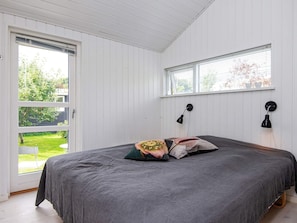 A bedroom with a bed, a window with blinds, and a door leading to a balcony. - 4 Star Holiday Home in Malling (Malling)