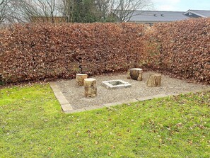 Un espace jardin aménagé avec un foyer et des sièges.