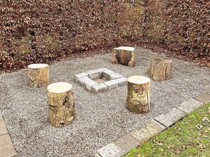A garden area with a gravel path, surrounded by a hedge of brown leaves. - 4 Star Holiday Home in Juelsminde (Horsens)