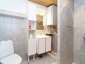 A bathroom with a toilet, a sink, a mirror, and a shower. - 4 Person Holiday Home in Graested (Graested)