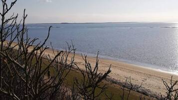 A beach with a clear view of the ocean and a distant shoreline.