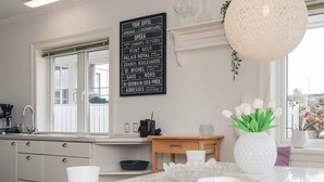 Una cocina moderna con encimera de mármol, lámpara colgante y un cartel decorativo que enumera puntos emblemáticos de París.
