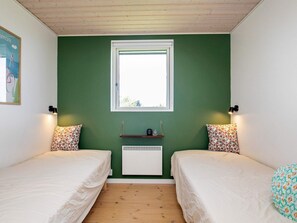 A bedroom with two single beds, a window, a radiator, and a wall-mounted shelf. - 4 Star Holiday Home in Otterup (Otterup)