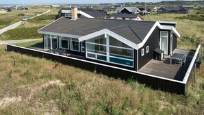 A modern coastal house with a large glass balcony, a swimming pool, and a deck area. - 8 Person Holiday Home in Hjorring (Hjørring)