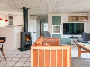 Una sala de estar con chimenea, televisión y comedor.