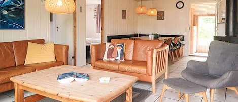 A cozy living room with a wooden coffee table, leather sofas, and a grey armchair.