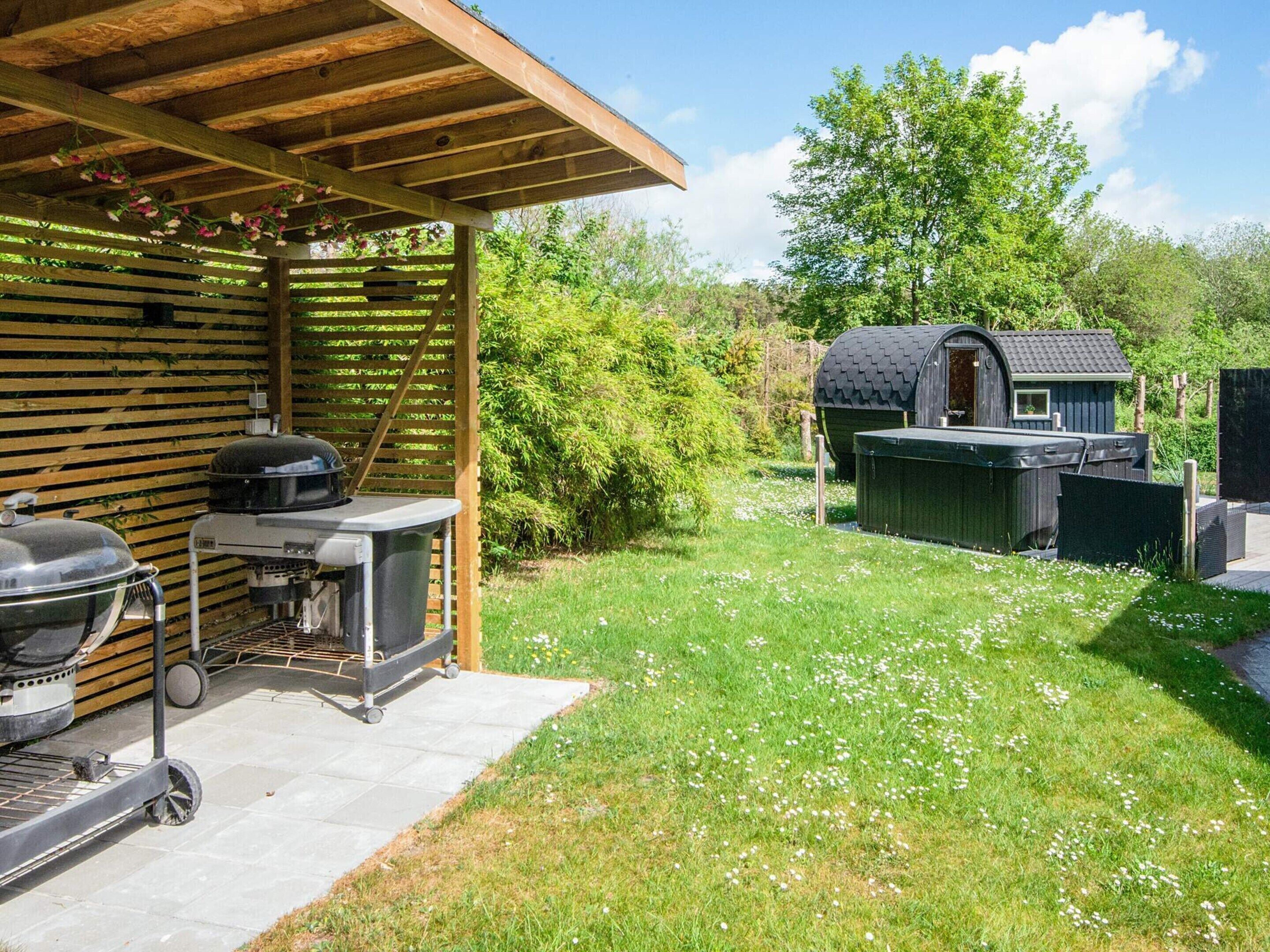 A covered outdoor area with a grill, a small shed, and a garden.