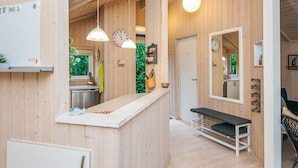A wooden interior with a kitchen area, a bench, and a mirror. - 4 Star Holiday Home in Ebeltoft (Ebeltoft)