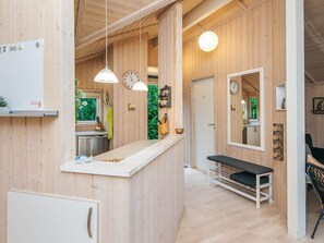 A wooden interior with a kitchen area, a bench, and a mirror. - 4 Star Holiday Home in Ebeltoft (Ebeltoft)