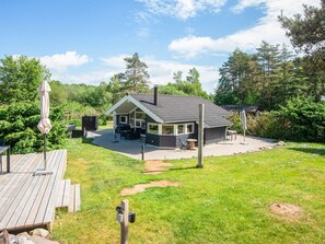 A house with a patio, outdoor seating, and a deck. - 4 Star Holiday Home in Ebeltoft (Ebeltoft)