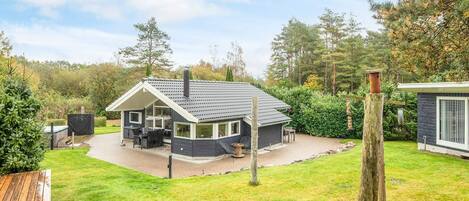 A house with a covered patio, a chimney, and a fenced yard.