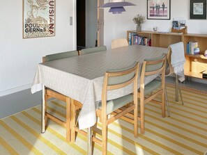 A dining area with a table and chairs, a bookshelf, and a lamp. - 4 Star Holiday Home in Thyboron (Thyborøn)