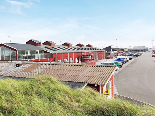 A red building with a parking lot in front.