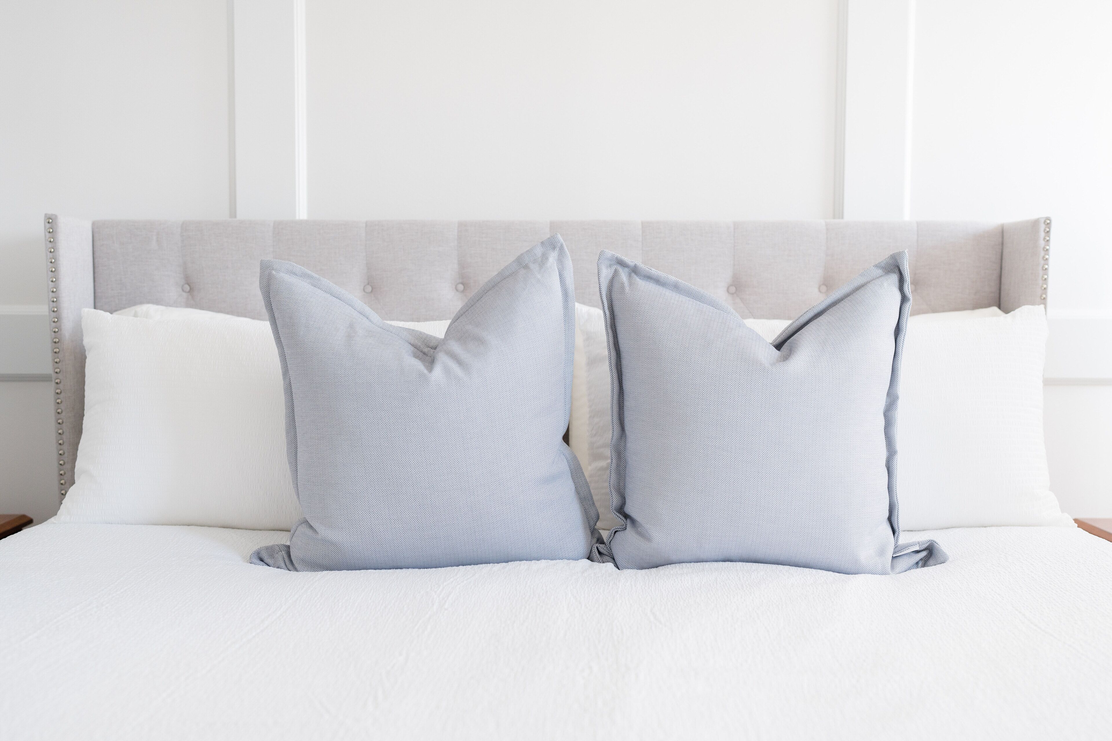 A neatly made bed with two pillows and a headboard.