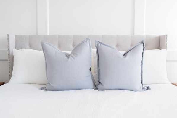 A neatly made bed with two pillows and a headboard.