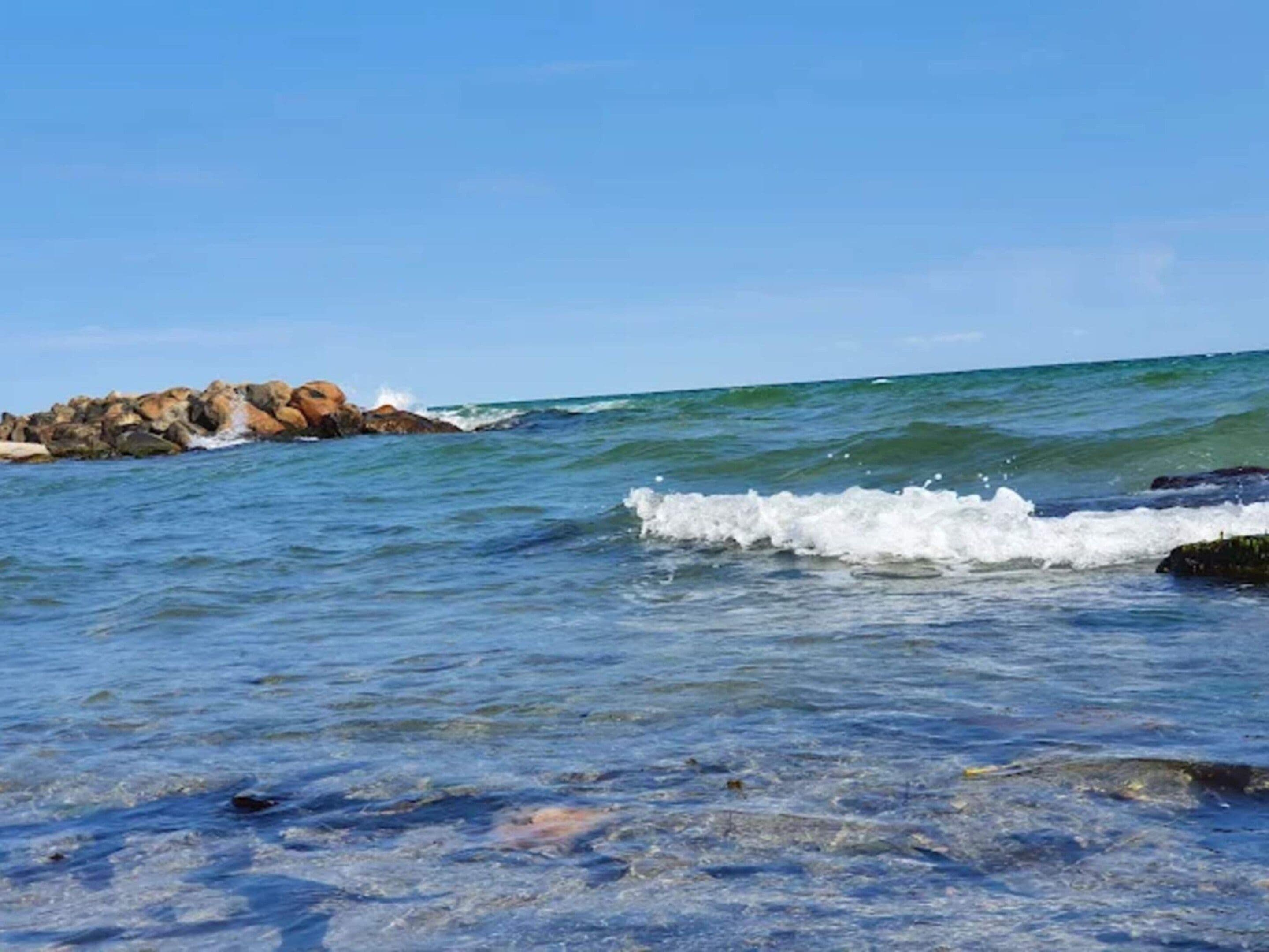 A rocky shoreline with waves crashing onto the rocks.