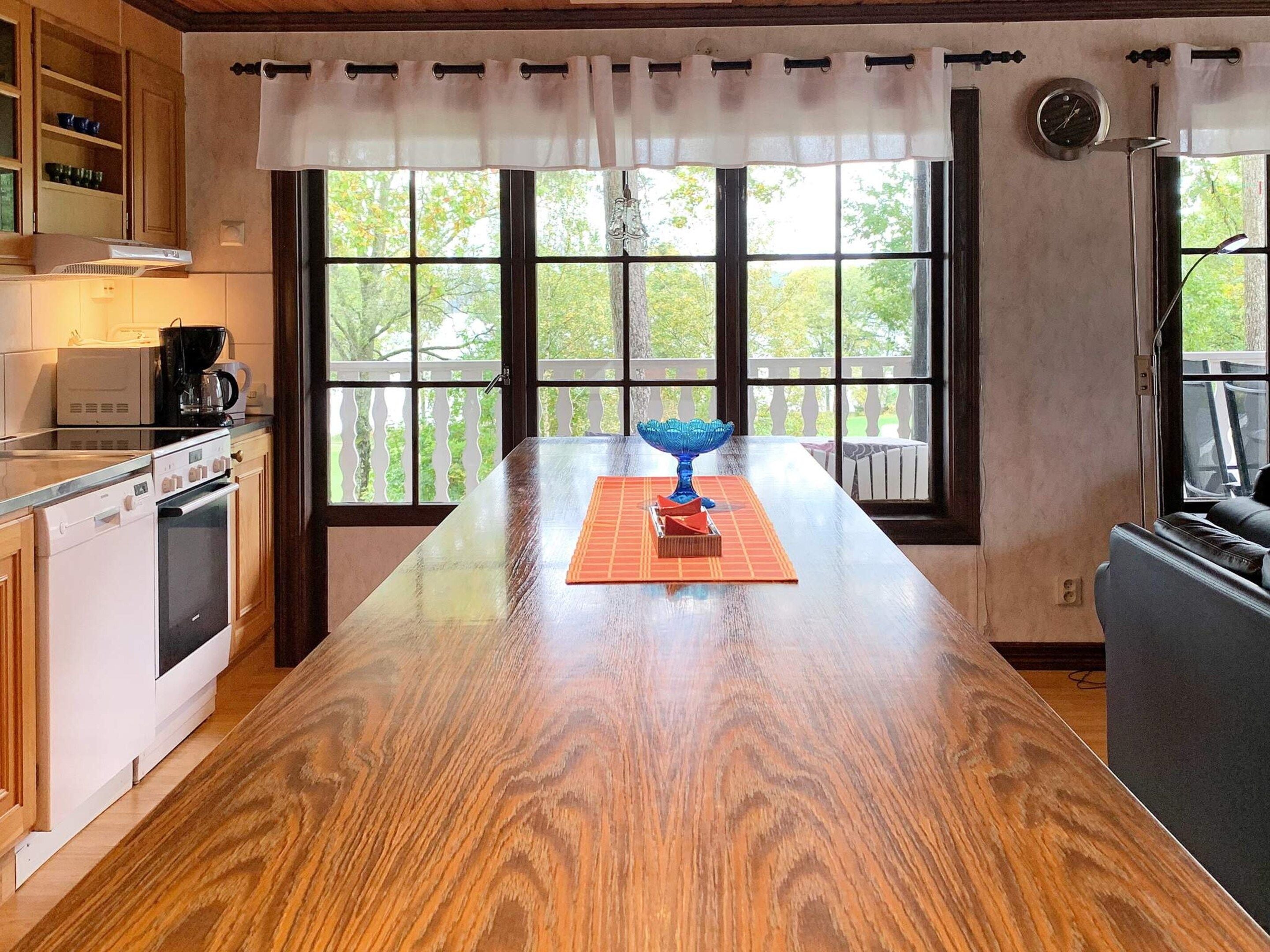 A kitchen with a wooden island, a coffee maker, and a window with a view of trees.
