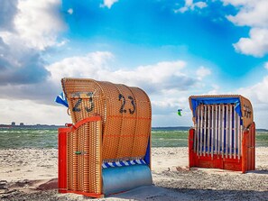 Two beach huts with numbers 23 and 24, a sandy beach, and a view of the sea. - 5 Star Holiday Home in Wendtorf (Wendtorf)