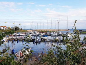 A marina with multiple boats docked, a sandy beach in the background, and a clear sky. - 4 Star Holiday Home in Smygehamn (Trelleborg)