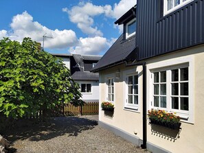 A two-story house with a gravel driveway and a large tree in the foreground. - 5 Person Holiday Home in Smygehamn (Trelleborg)