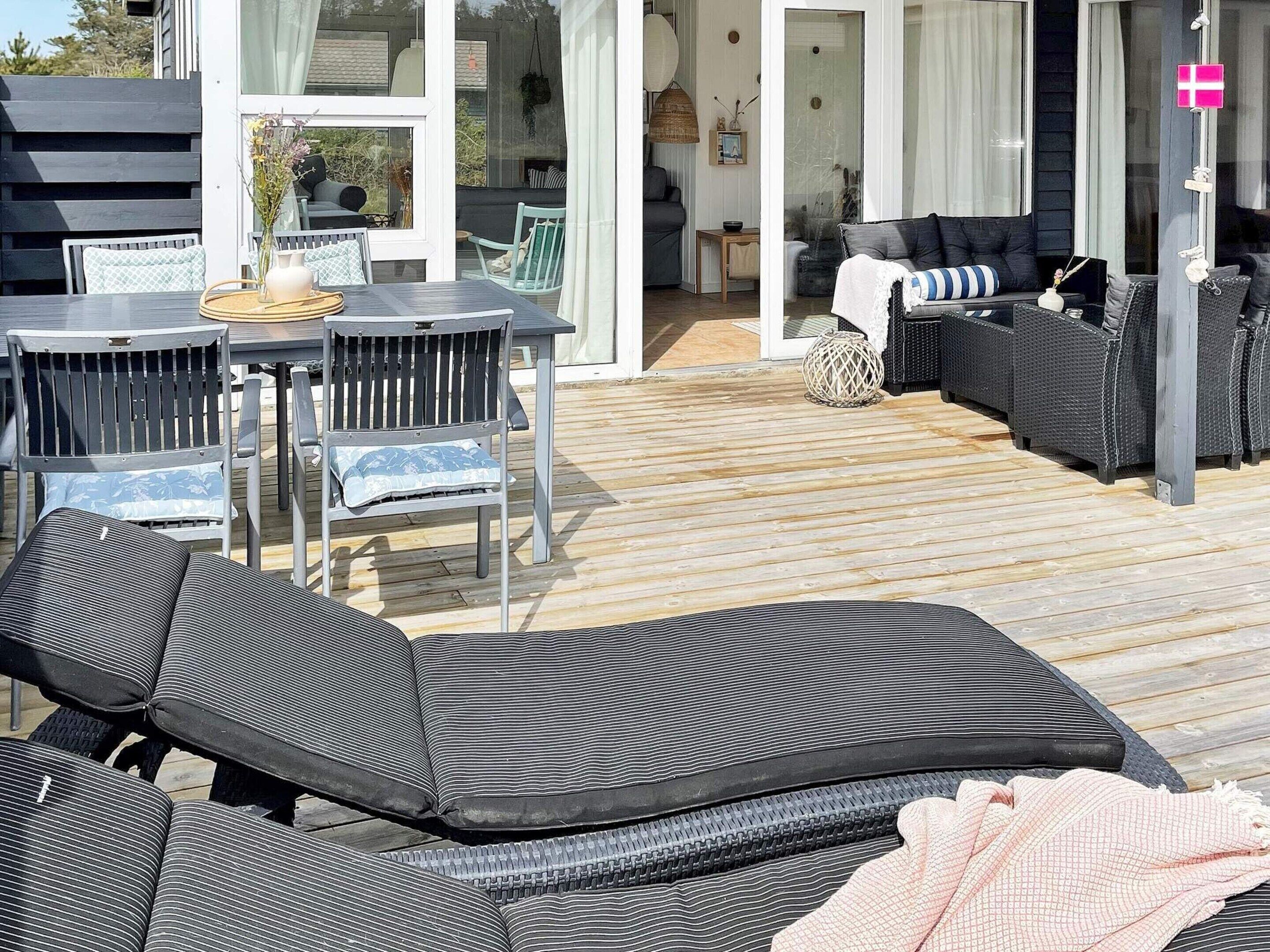 Une terrasse aménagée avec du mobilier d’extérieur, notamment un canapé, des chaises et une table à manger.