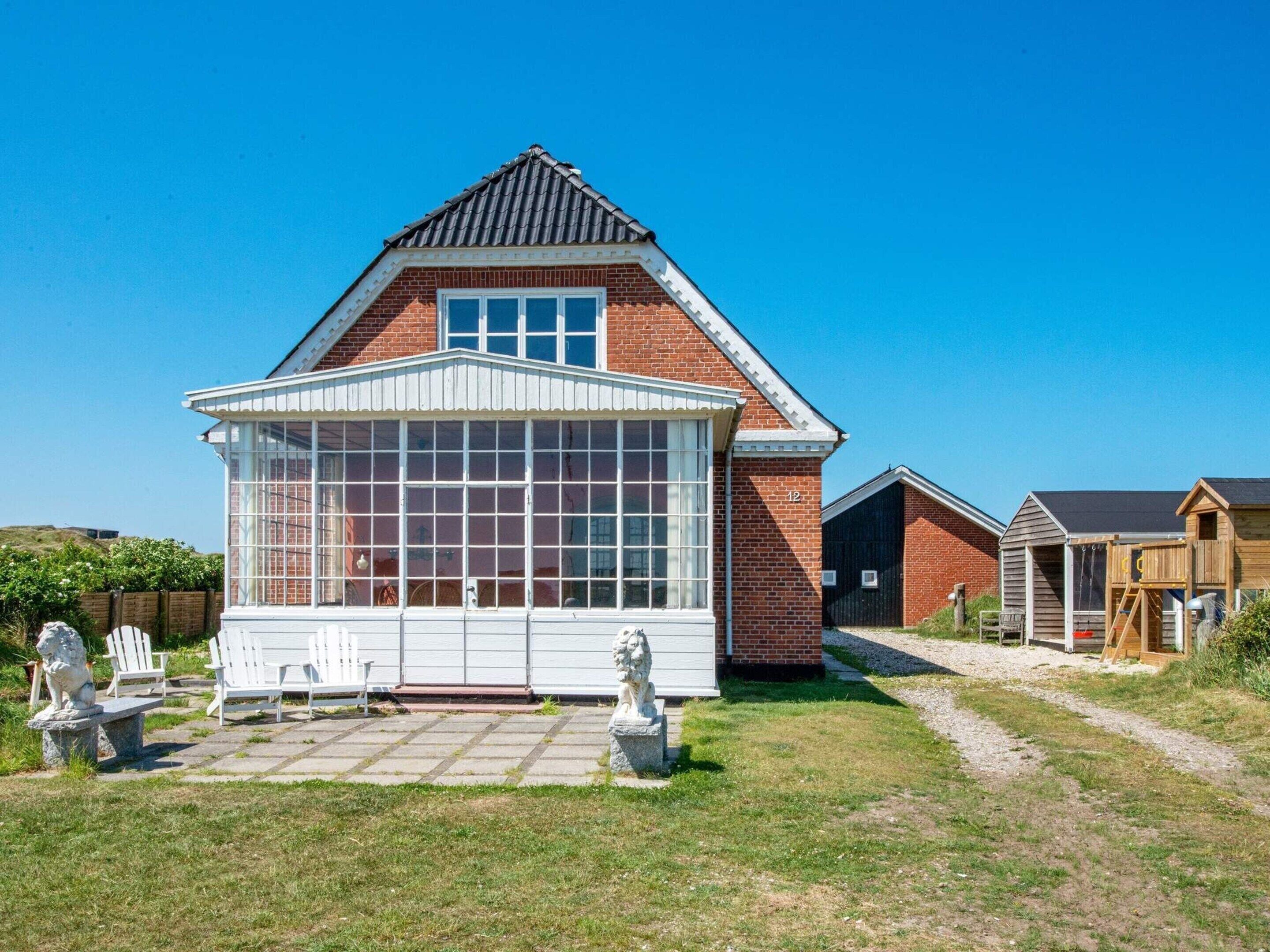 A brick house with a large window and a small porch.