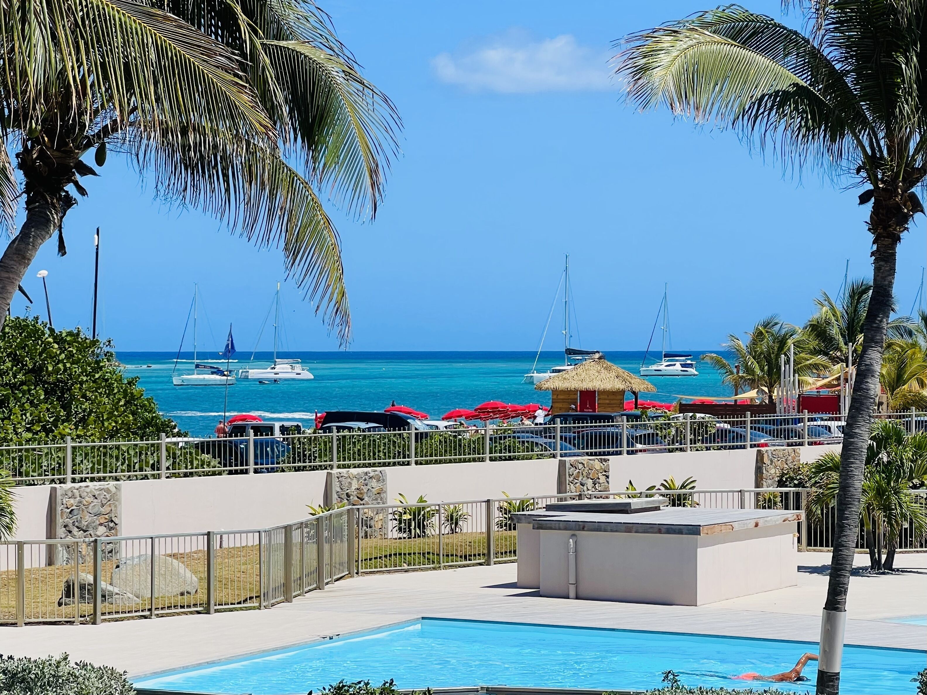 Un espace piscine offrant une vue sur l’océan et les bateaux.