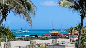 A pool area with a view of the ocean and boats.