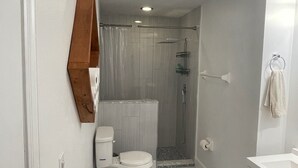 Une salle de bain avec des toilettes, une douche et un lavabo.