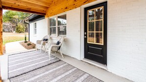 A white brick house with a black front door, two windows, and a covered porch with two wicker chairs. - 100% - 5 STAR reviews!   Legendary Getaway! (Township of Taylorsville)