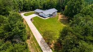 An aerial view of a house surrounded by dense forest, with a paved driveway leading to the entrance. - 100% - 5 STAR reviews!   Legendary Getaway! (Township of Taylorsville)